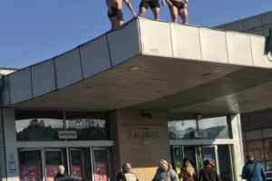 "Гаряче" привітання для жінок: троє чоловіків з оголеним торсом залізли на дах станції метро "Дарниця" – фото