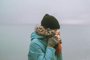 Жінка у зимовій куртці та шапці