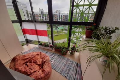 Біло-червоно-білий прапор на вікні квартири
