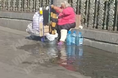 Женщина стирает одежду возле железнодорожного вокзала в Киеве