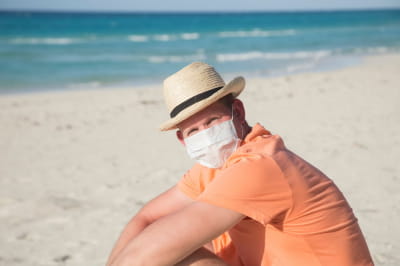 Чоловік у захисній масці поблизу моря