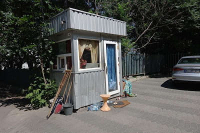 Зайнята безхатченками будка на парковці 