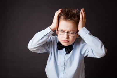 Хлопчик тримається за голову