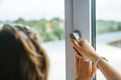 Женщина закрывает окно 