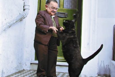 Генри Беренс, самый маленький человек в мире, танцует со своим домашним котом в дверях своего дома в Вортинге, 1956 год.