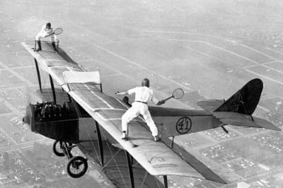 Это реальная фотография двух людей, Глэдис Рой и Ивана Ангера, играющих в теннис на борту летящего на высоте 3000 футов самолета в ноябре 1925 года.