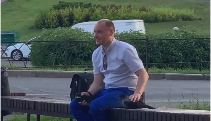 Мужчина гладит ворону