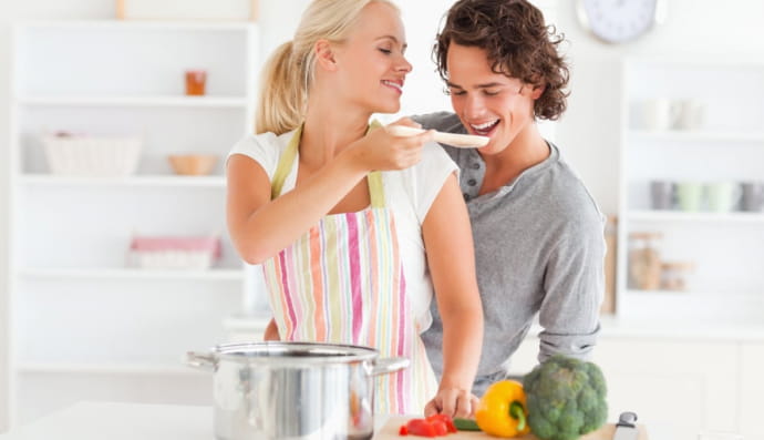 Женщина дает попробовать мужчине суп