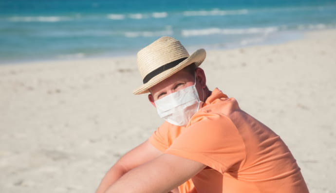 Чоловік у захисній масці поблизу моря