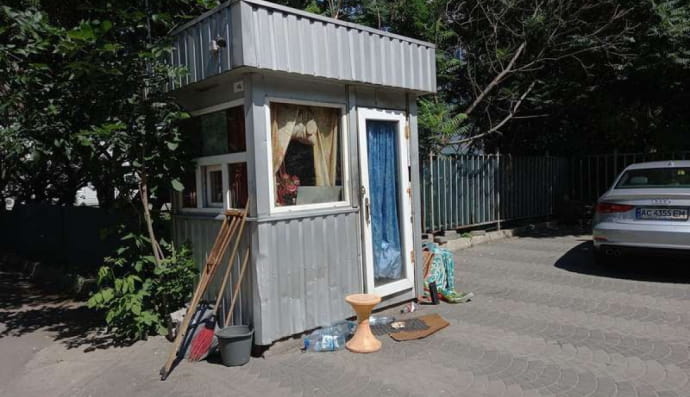 Зайнята безхатченками будка на парковці 