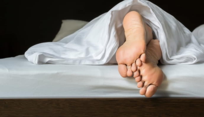 Ноги, що стирчать з-під ковдри