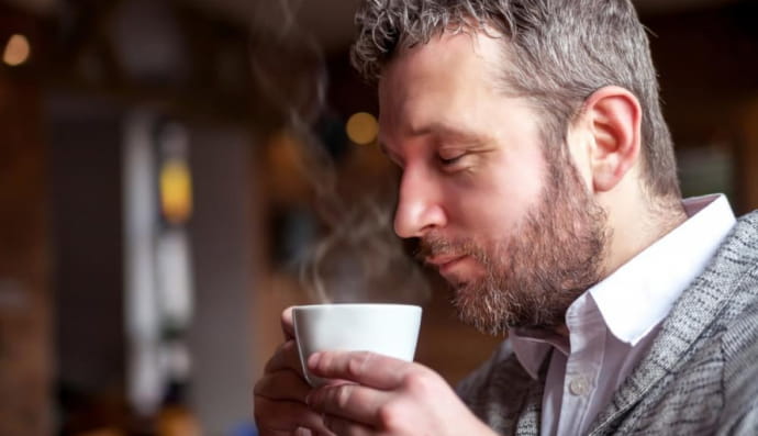 Чоловік п'є теплий напій