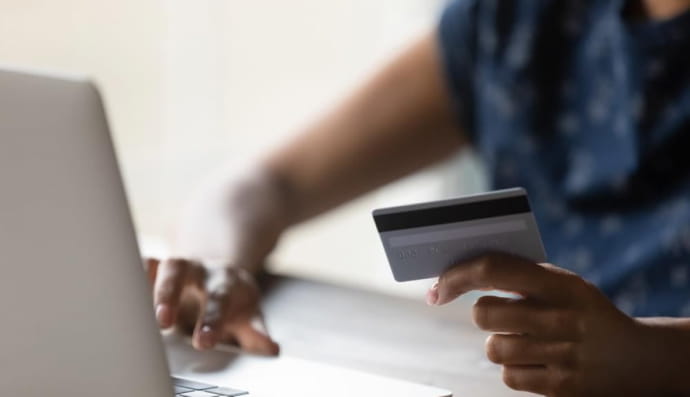 Женщина держит банковскую карточку 