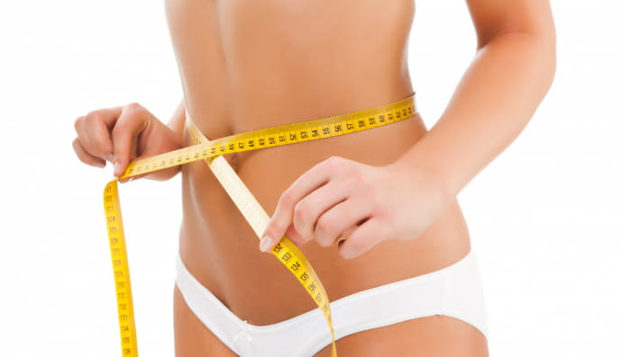 Жінка, яка вимірює талію