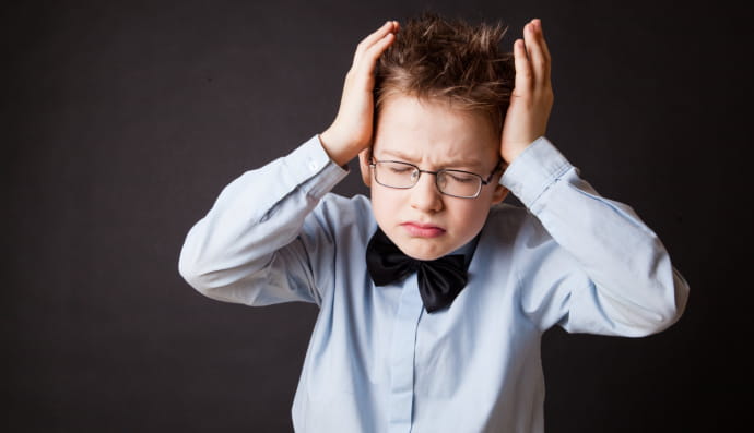 Мальчик держится за голову