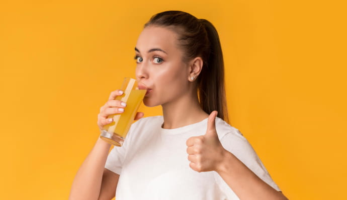 Женщина пьет из стакана 