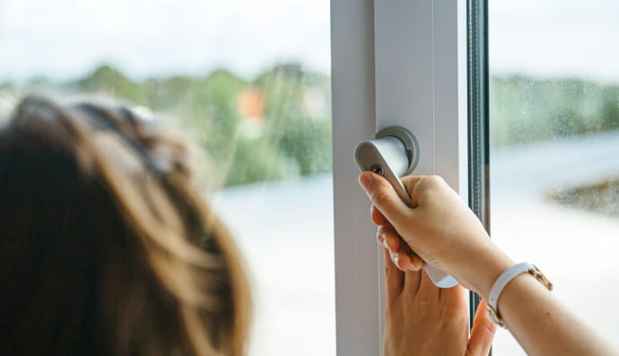 Женщина закрывает окно 