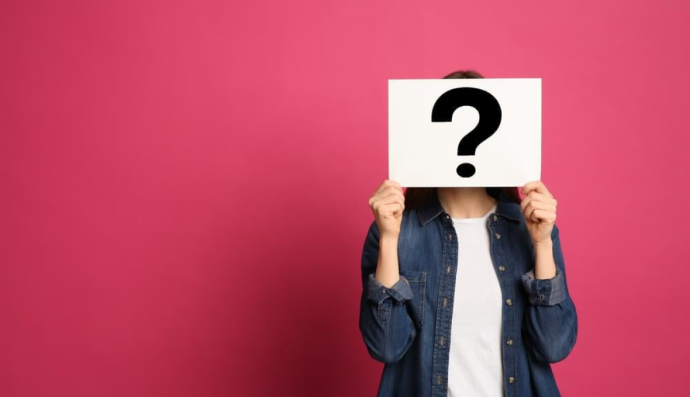 Жінка тримає табличку зі знаком питання