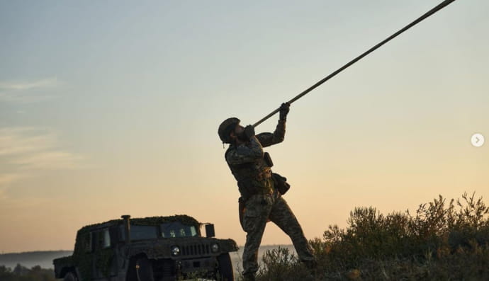 Військовий грає на карпатській трембіті