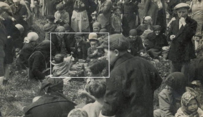 Ребенок дает другому ребенку цветок в Аушвице, сидя в роще возле газовой камеры перед его убийством. Май 1944 года.