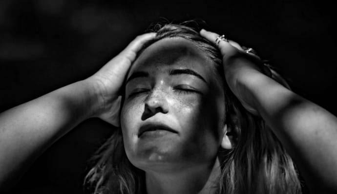 Жінка тримається за голову