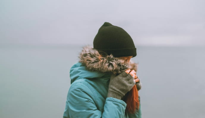 Жінка у зимовій куртці та шапці