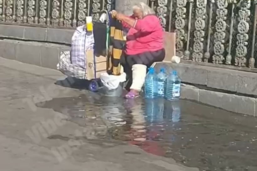 Жінка пере одяг біля залізничного вокзалу в Києві